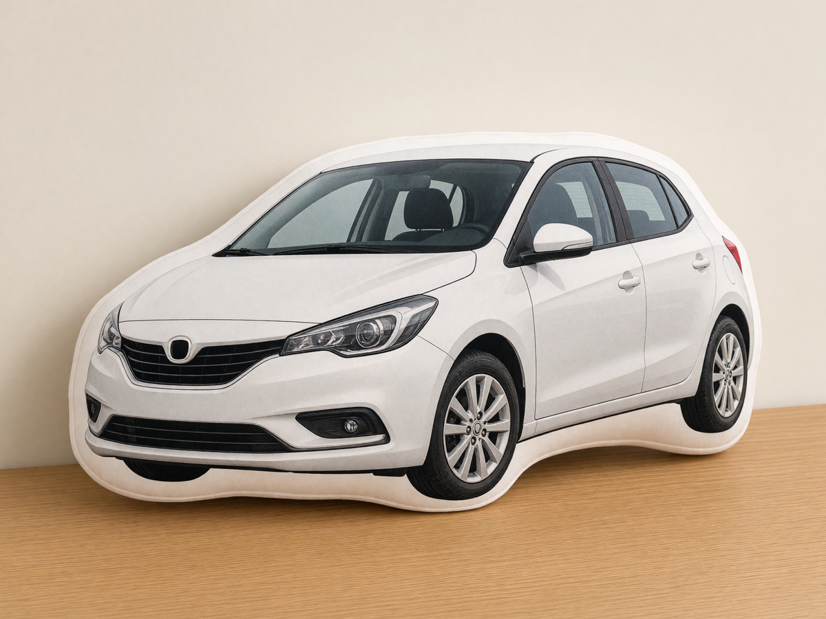 Die-cut white hatchback photo pillow on a table